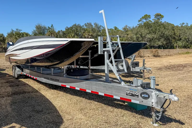 Slide: The Image of 2018 MTI 340X boat on Myco trailer, parked on grass with trees in background. - 3