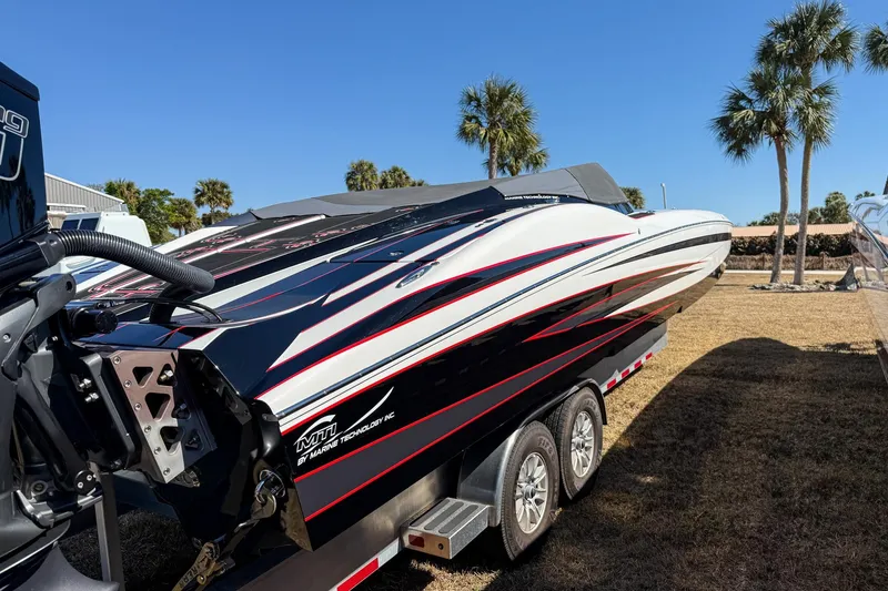 Slide: The Image of 2018 MTI 340X powerboat on trailer, sleek design, palm trees in background. - 8