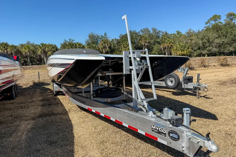 Slide: The Image of 2018 MTI 340X boat on trailer in grassy area, clear blue sky background. - 9