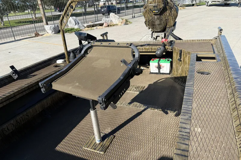 Slide: The Image of 2022 Prodigy 1854 boat interior with seat and battery, parked outdoors. - 8