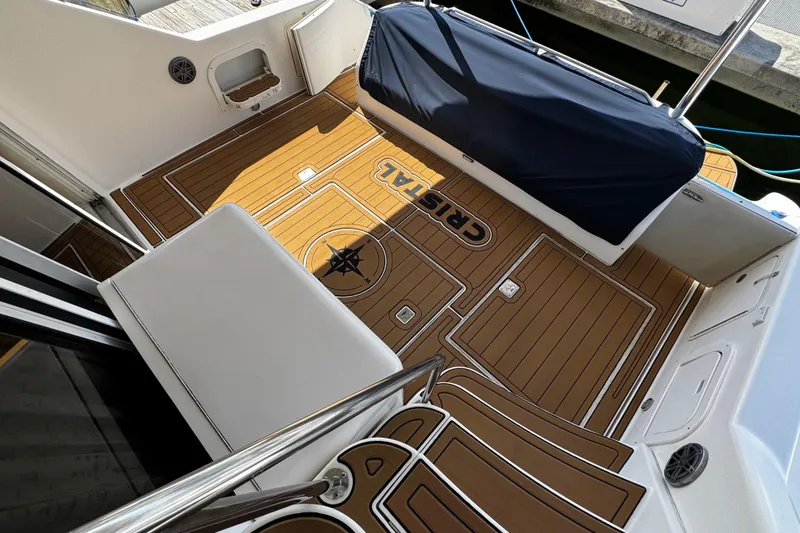 Slide: The Image of 1999 Sea Ray 440 Express Bridge deck with custom teak flooring and seating. - 10