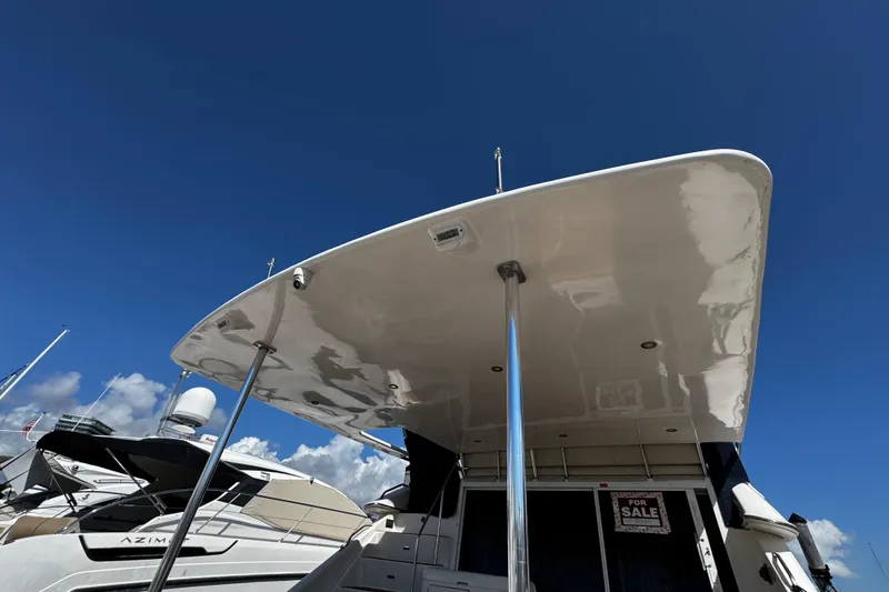 Slide: The Image of 1999 Sea Ray 440 Express Bridge yacht with "For Sale" sign under clear blue sky. - 11