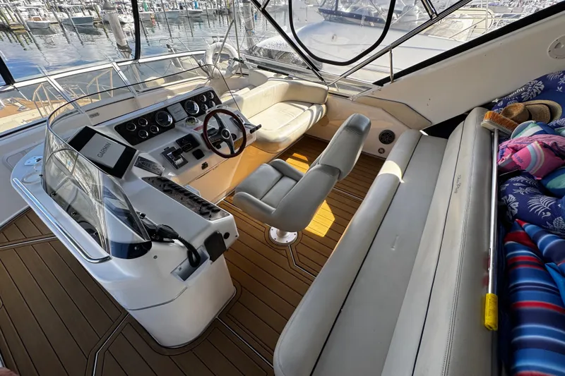Slide: The Image of 1999 Sea Ray 440 Express Bridge cockpit with helm, seating, and marina view. - 17