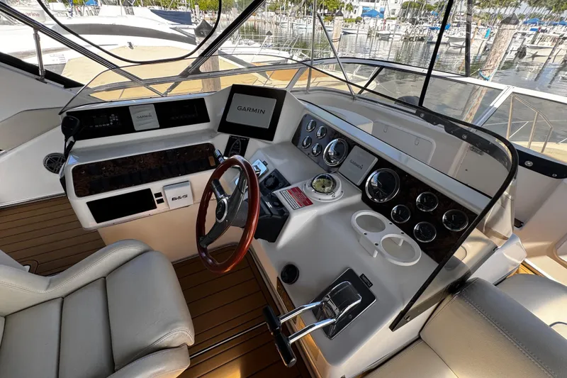 Slide: The Image of 1999 Sea Ray 440 Express Bridge helm with Garmin navigation and leather seating. - 18