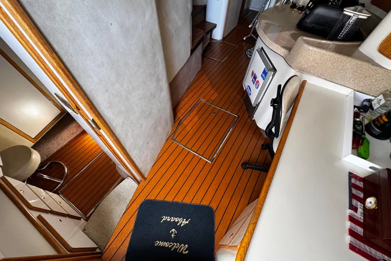 Slide: The Image of 1999 Sea Ray 440 Express Bridge interior with wood flooring and modern amenities. - 23