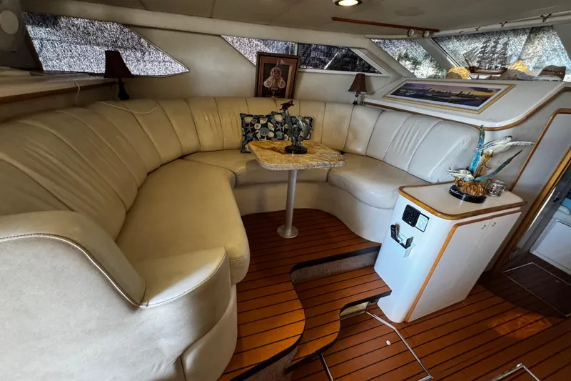 Slide: The Image of Luxurious 1999 Sea Ray 440 Express Bridge interior with elegant seating and wooden flooring. - 29