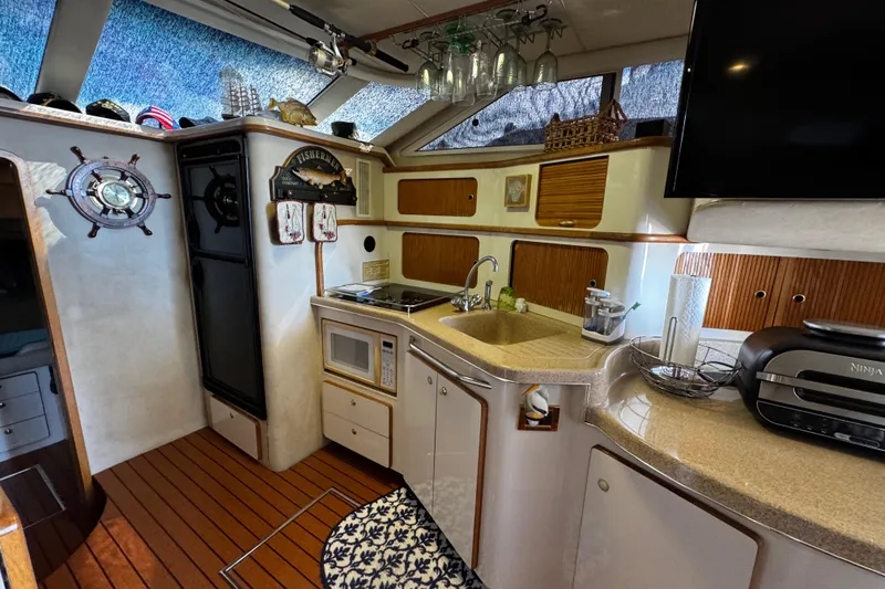 Slide: The Image of Interior of 1999 Sea Ray 440 Express Bridge yacht with kitchen and nautical decor. - 30