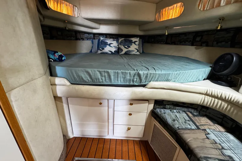 Slide: The Image of 1999 Sea Ray 440 Express Bridge cabin with bed, storage, and seating. - 34