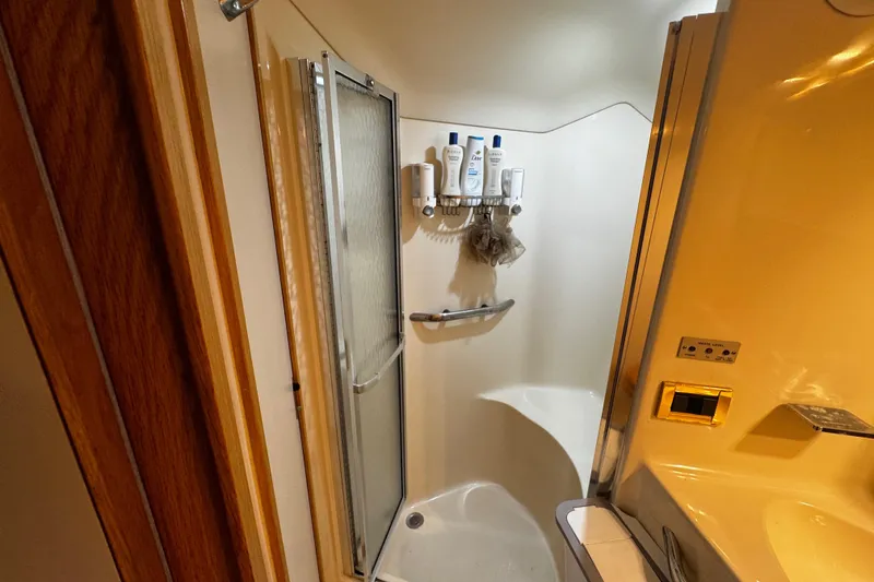 Slide: The Image of Bathroom interior of 1999 Sea Ray 440 Express Bridge yacht, featuring shower and toiletries. - 38