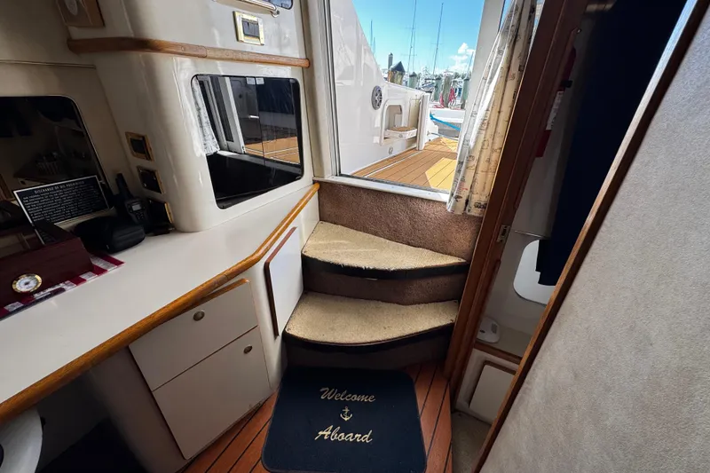 Slide: The Image of Interior of 1999 Sea Ray 440 Express Bridge with steps and "Welcome Aboard" mat. - 40