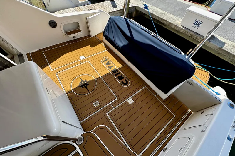Slide: The Image of 1999 Sea Ray 440 Express Bridge deck with custom wood flooring and compass design. - 7