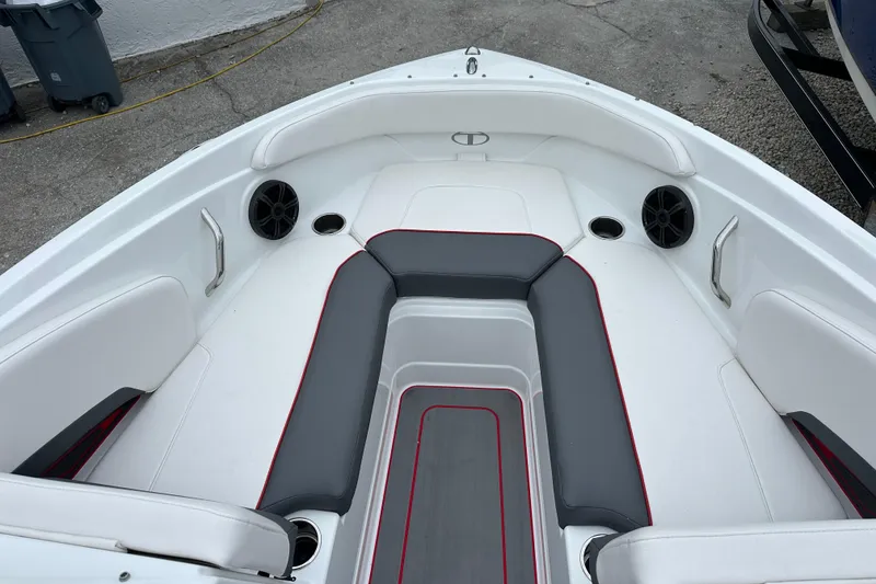 Slide: The Image of 2021 Tahoe 210 S boat interior with white and gray seating, cup holders, and speakers. - 11