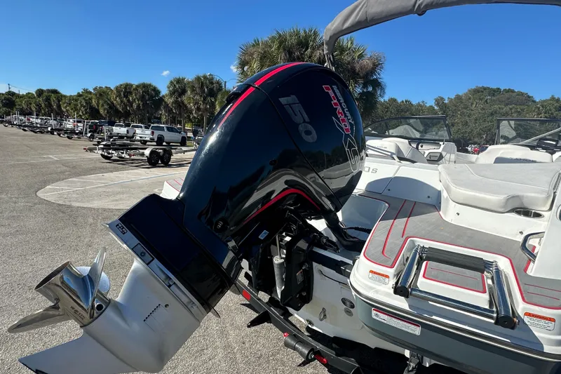 Slide: The Image of 2021 Tahoe 210 S boat with powerful outboard motor in sunny parking lot. - 4