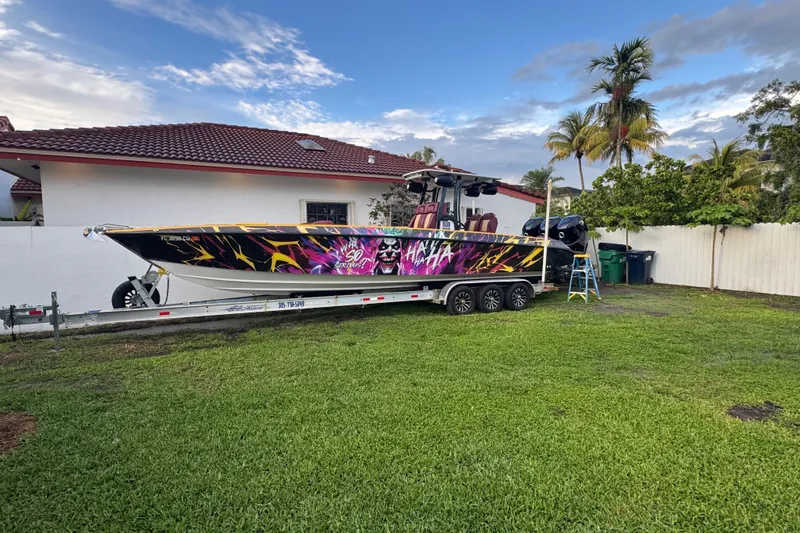 The Image of 1982 Scorpion 316 boat with vibrant graphics on a trailer beside a house. - 1