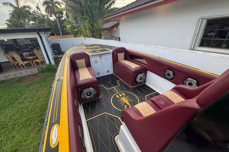Slide: The Image of 1982 Scorpion 316 boat interior with maroon and beige seating, custom flooring, and outdoor setting. - 10