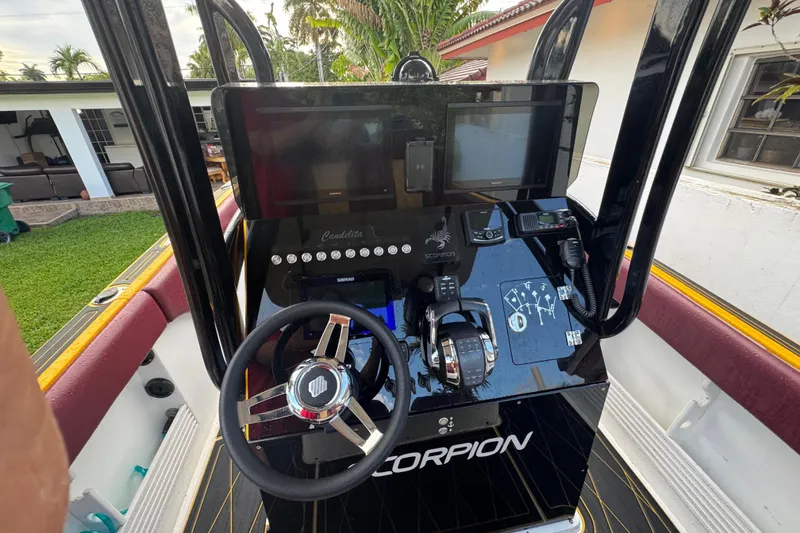 Slide: The Image of Control panel of a 1982 Scorpion 316 boat with steering wheel and navigation equipment. - 11