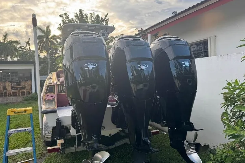 Slide: The Image of Triple outboard motors on a 1982 Scorpion 316 boat, parked outdoors. - 12