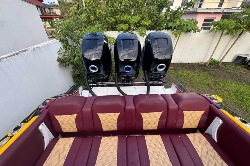 Slide: The Image of 1982 Scorpion 316 boat with three powerful outboard motors and maroon seating. - 14