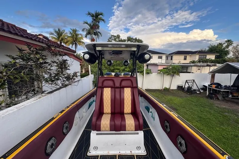 Slide: The Image of 1982 Scorpion 316 boat with maroon and gold seating, parked in a residential backyard. - 15