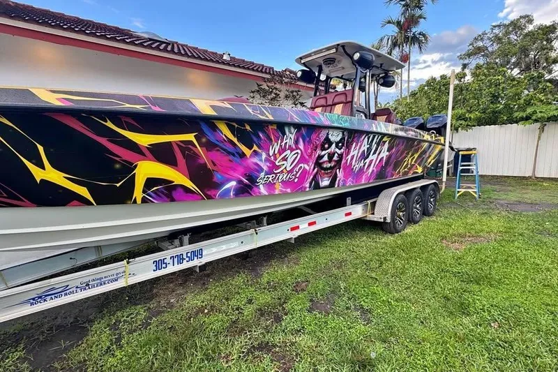 Slide: The Image of 1982 Scorpion 316 boat with vibrant graffiti art and "Why So Serious?" text on trailer. - 16