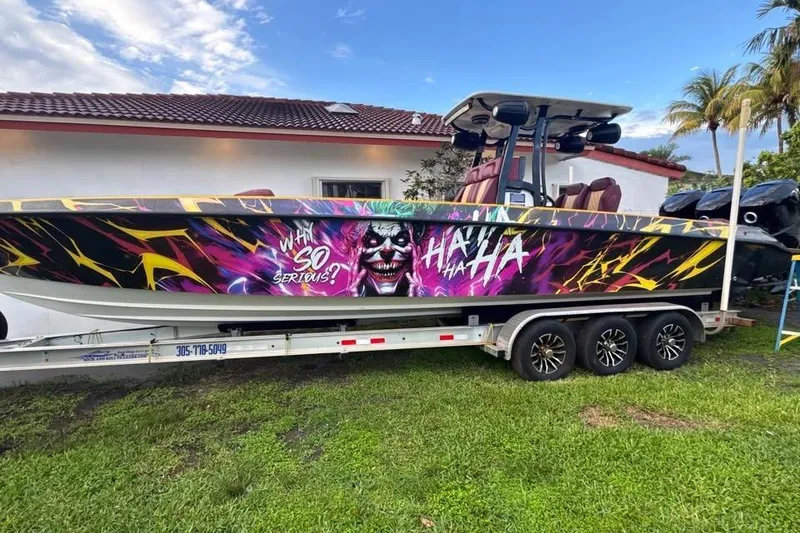 Slide: The Image of 1982 Scorpion 316 boat with vibrant Joker-themed artwork on trailer. - 17