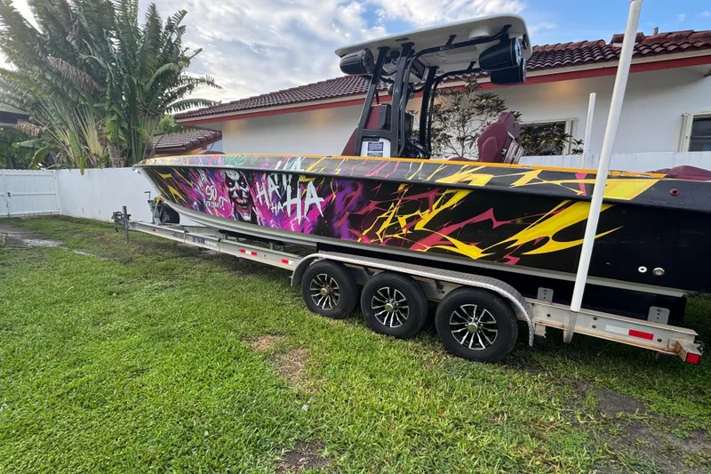Slide: The Image of 1982 Scorpion 316 boat with vibrant graffiti design on a trailer in a yard. - 2