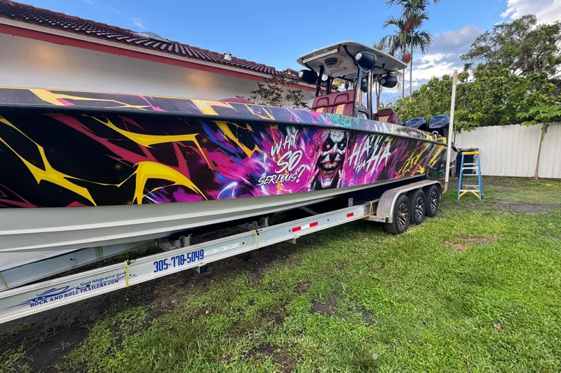 Slide: The Image of Colorful 1982 Scorpion 316 boat with vibrant graphics and trailer in a yard setting. - 3