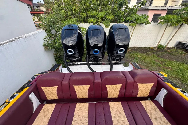 Slide: The Image of Vintage 1982 Scorpion 316 boat with triple outboard motors and maroon diamond-patterned seating. - 5