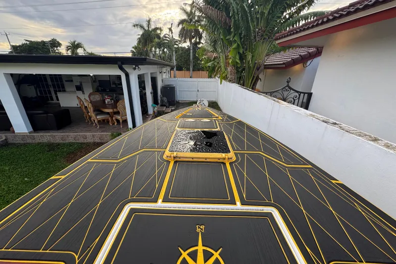 Slide: The Image of 1982 Scorpion 316 boat deck with geometric design, near a patio and tropical plants. - 8