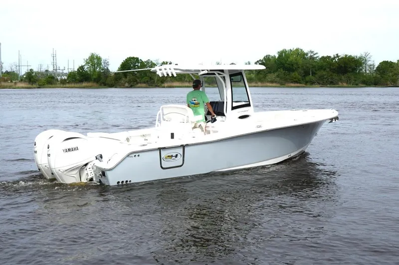 Slide: The Image of 2025 Sea Hunt Ultra 265 SE boat cruising on a calm river with Yamaha engines. - 3