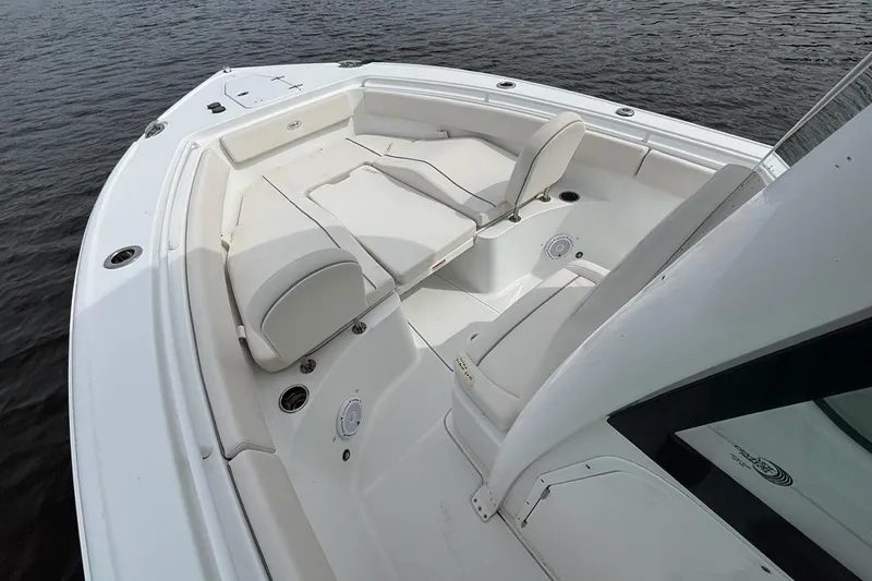 Slide: The Image of 2025 Sea Hunt Ultra 265 SE boat interior with white cushioned seating on calm water. - 8