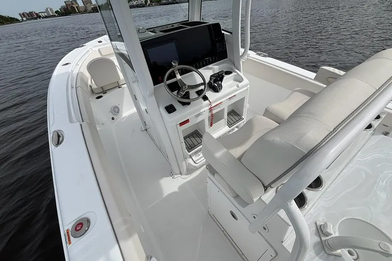 Slide: The Image of 2025 Sea Hunt Ultra 265 SE boat interior with steering console on calm water. - 9