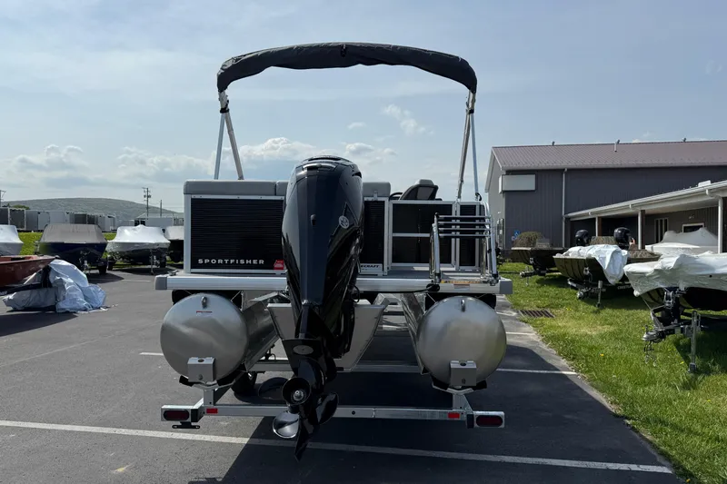 Slide: The Image of 2025 Princecraft Sportfisher 21-2S pontoon boat with outboard motor in a marina setting. - 2