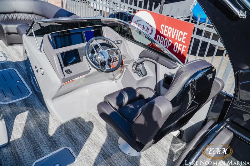 Slide: The Image of 2025 Bennington 25QSBWA boat helm with modern controls and comfortable seating at Lake Norman Marina. - 10