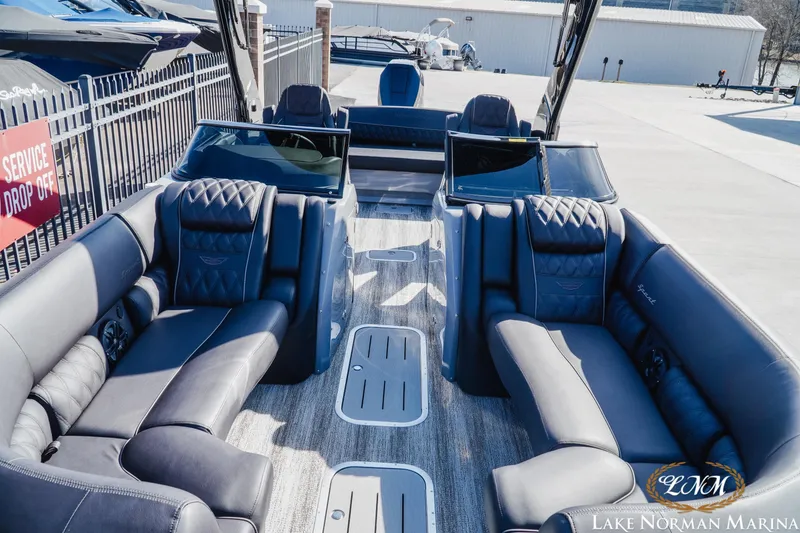 Slide: The Image of 2025 Bennington 25QSBWA luxury pontoon boat interior with plush seating at Lake Norman Marina. - 14