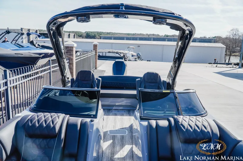 Slide: The Image of 2025 Bennington 25QSBWA luxury pontoon boat at Lake Norman Marina, showcasing sleek design and seating. - 15