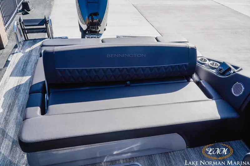 Slide: The Image of 2025 Bennington 25QSBWA boat interior with luxurious seating and cup holders at Lake Norman Marina. - 18