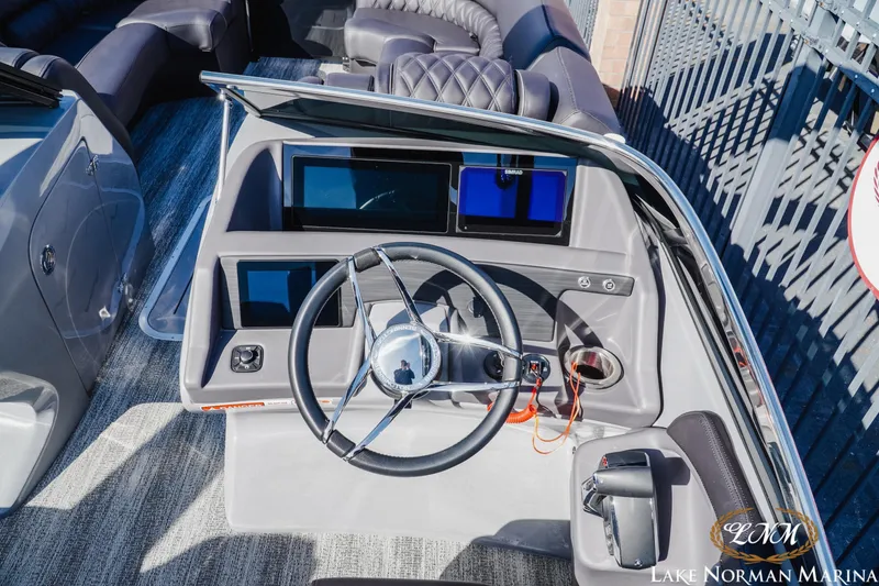 Slide: The Image of 2025 Bennington 25QSBWA boat dashboard with modern steering and digital displays at Lake Norman Marina. - 19