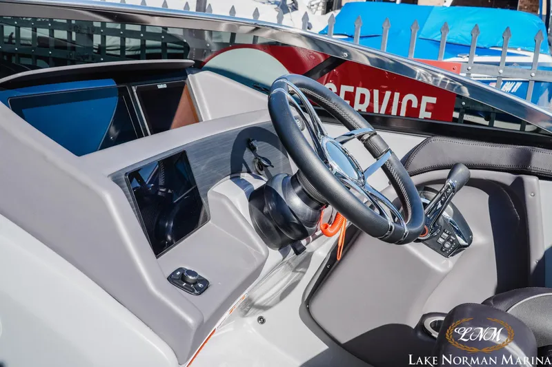 Slide: The Image of Interior view of 2025 Bennington 25QSBWA boat dashboard with steering wheel and controls. - 21
