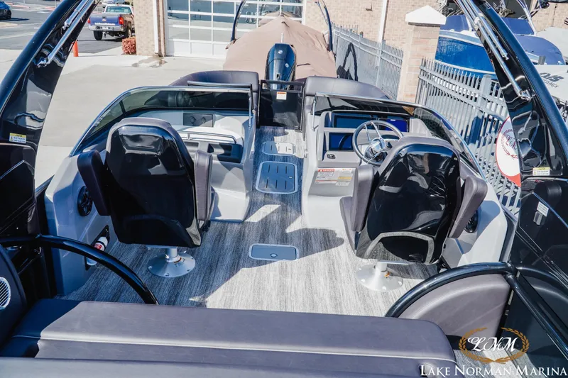 Slide: The Image of 2025 Bennington 25QSBWA pontoon boat interior with modern seating and steering wheel. - 8