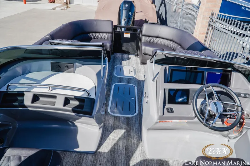 Slide: The Image of 2025 Bennington 25QSBWA boat interior with modern dashboard and luxurious seating at Lake Norman Marina. - 9
