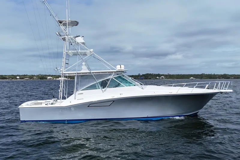 The Image of 1998 Cabo 45 Express yacht on open water, showcasing sleek design and fishing tower. - 0