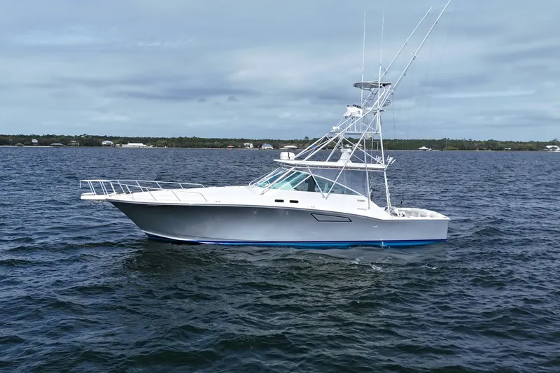 Slide: The Image of 1998 Cabo 45 Express yacht on open water, side view. - 10