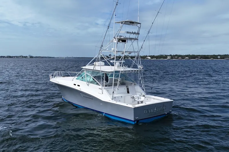 Slide: The Image of 1998 Cabo 45 Express boat on open water, featuring a sleek design and fishing tower. - 11
