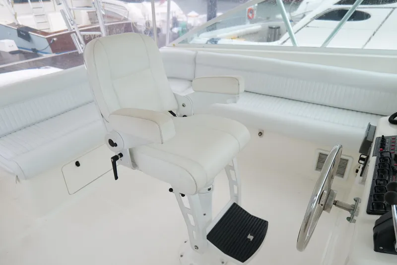 Slide: The Image of 1998 Cabo 45 Express boat helm with white captain's chair and steering wheel. - 18