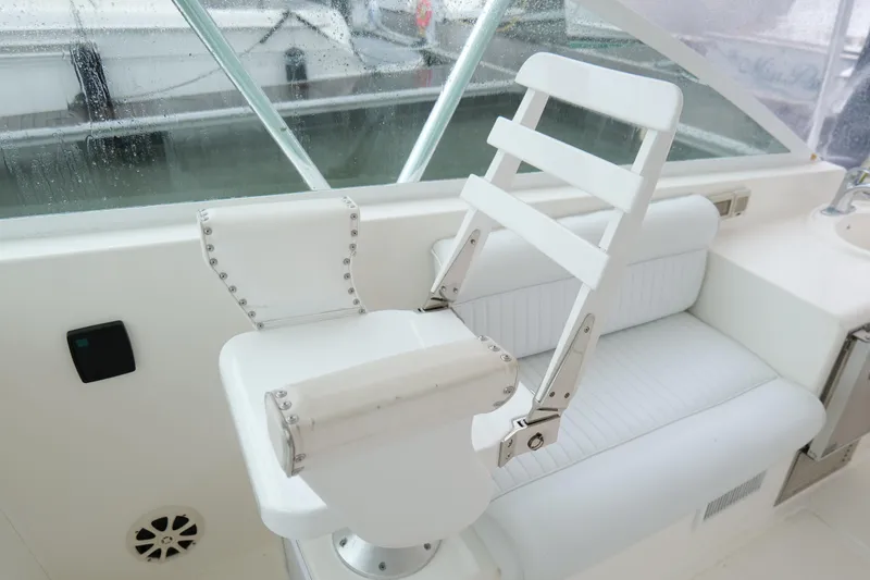 Slide: The Image of White captain's chair on 1998 Cabo 45 Express boat, featuring sleek design and rivet details. - 20