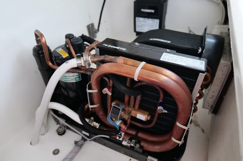 Slide: The Image of 1998 Cabo 45 Express engine room with Dometic cooling system and copper piping. - 22