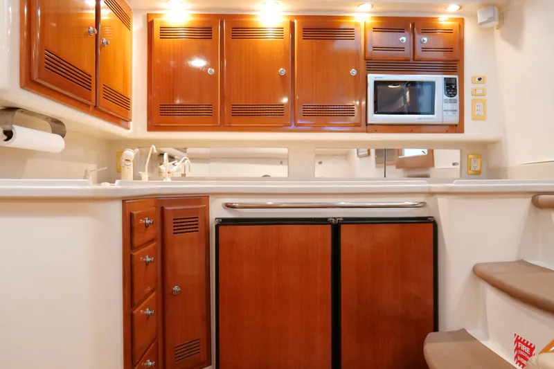 Slide: The Image of Luxurious 1998 Cabo 45 Express yacht kitchen with wooden cabinets and modern appliances. - 24