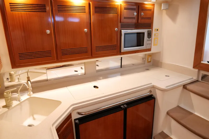 Slide: The Image of Luxurious 1998 Cabo 45 Express yacht kitchen with wood cabinets and modern appliances. - 26