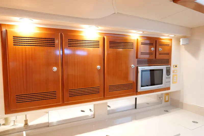 Slide: The Image of Luxurious wooden cabinetry and microwave in 1998 Cabo 45 Express yacht interior. - 27